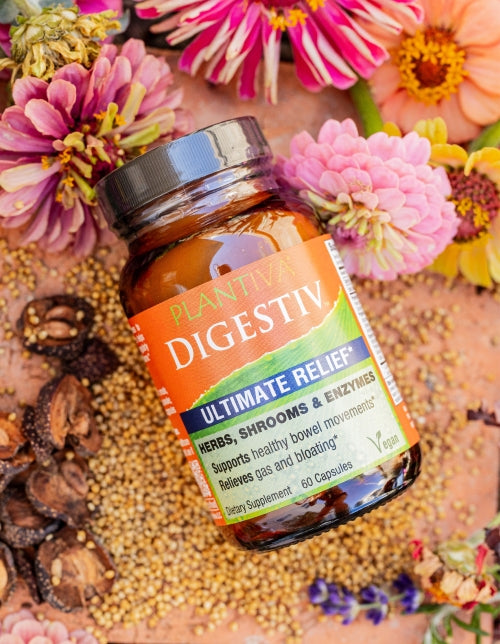 A bottle of Digestiv with flowers and other botanicals