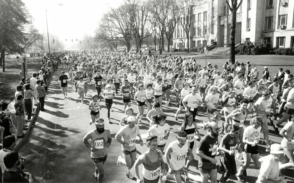 A historical black and white photo of runners