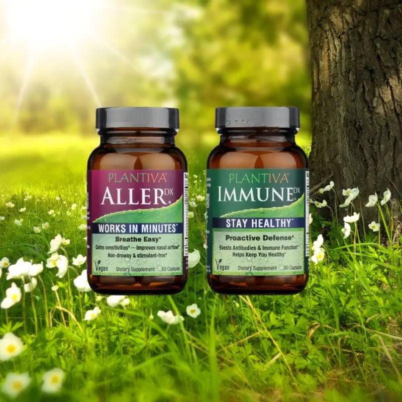 A bottle of AllerDx and a bottle of ImmuneDx on a background of a sunny meadow with flowers, grass and trees