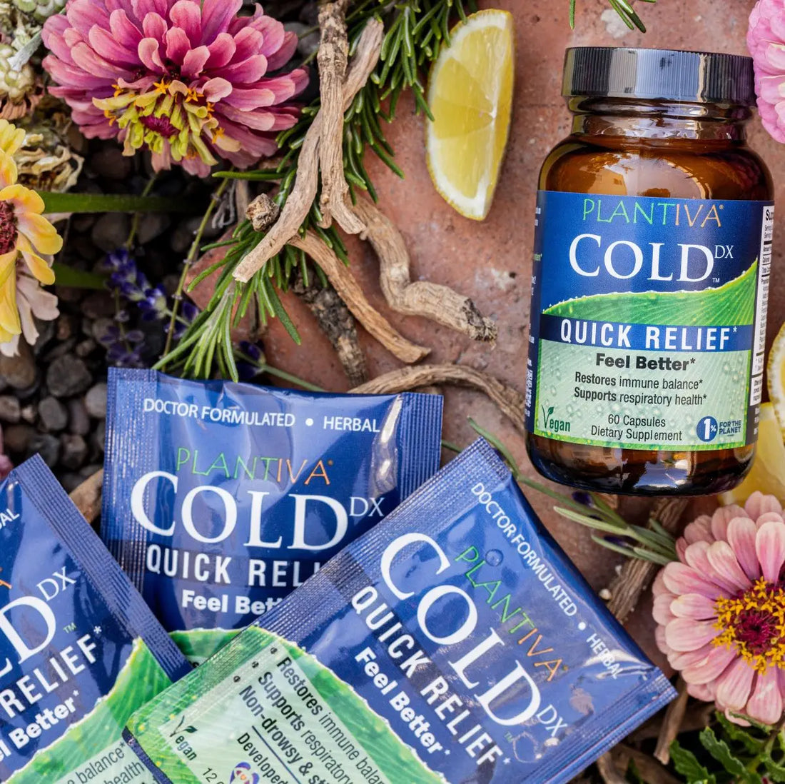Cold DX quick relief supplement packets and bottle surrounded by flowers and herbs.