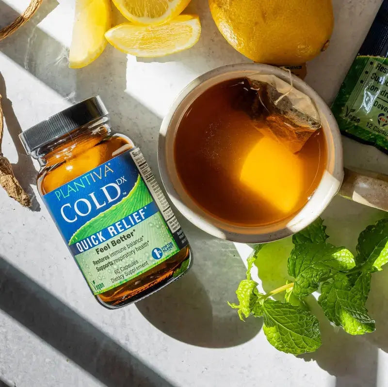 Plantiva Cold Dx Quick Relief supplement bottle with a cup of tea, lemon, and mint leaves on a counter.