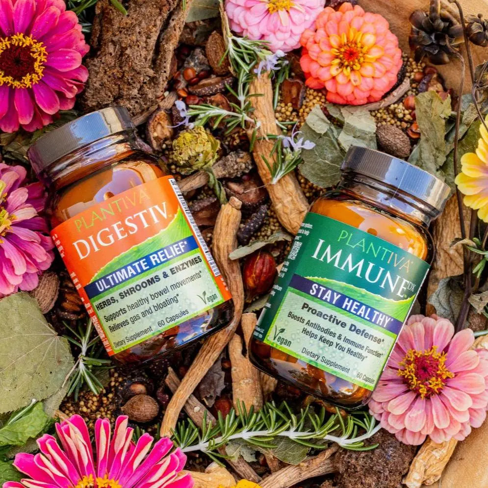 A bottle of Digestiv and a bottle of ImmuneDx with flowers and other botanicals
