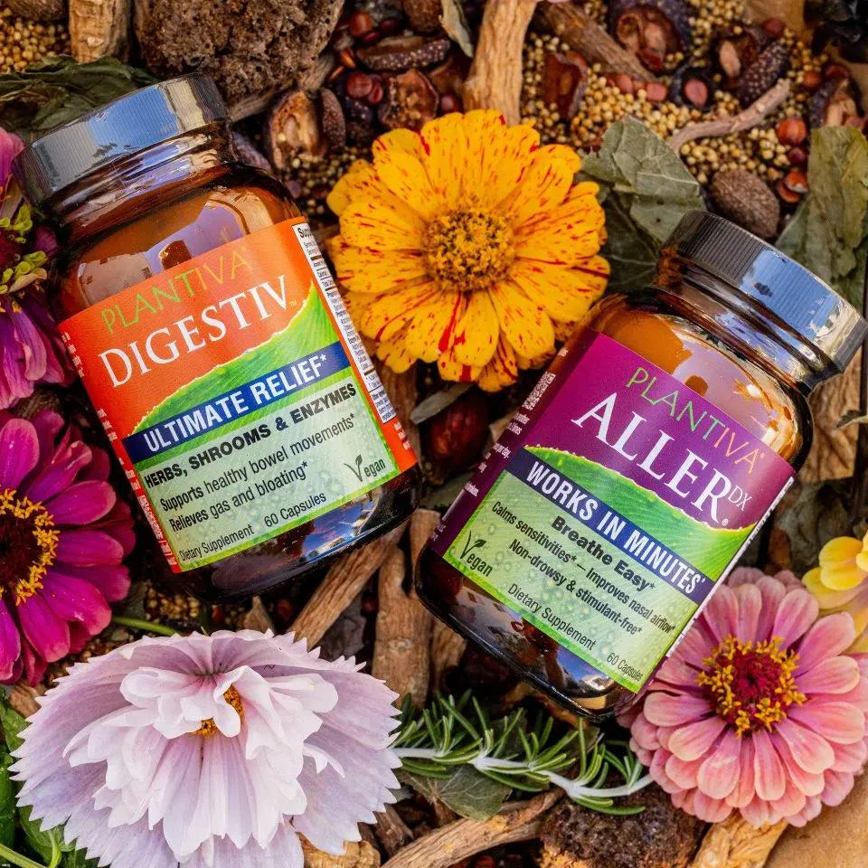 A bottle of AllerDx and a bottle of Digestiv with flowers and other botanicals