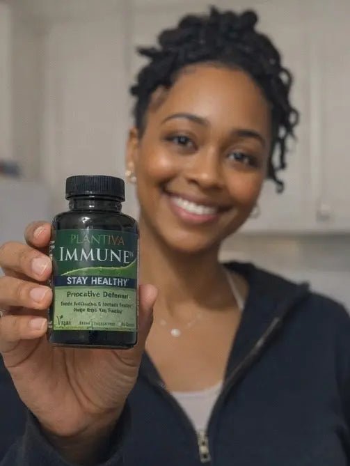 Woman holding a bottle of Plantiva Immune supplement in a kitchen setting