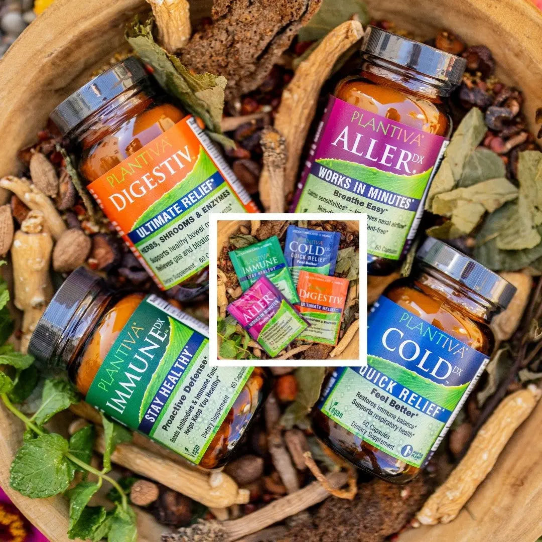 Bottles and packets of Digestiv, AllerDx, ImmuneDx and ColdDx in a wooden bowl with leaves and other botanicals